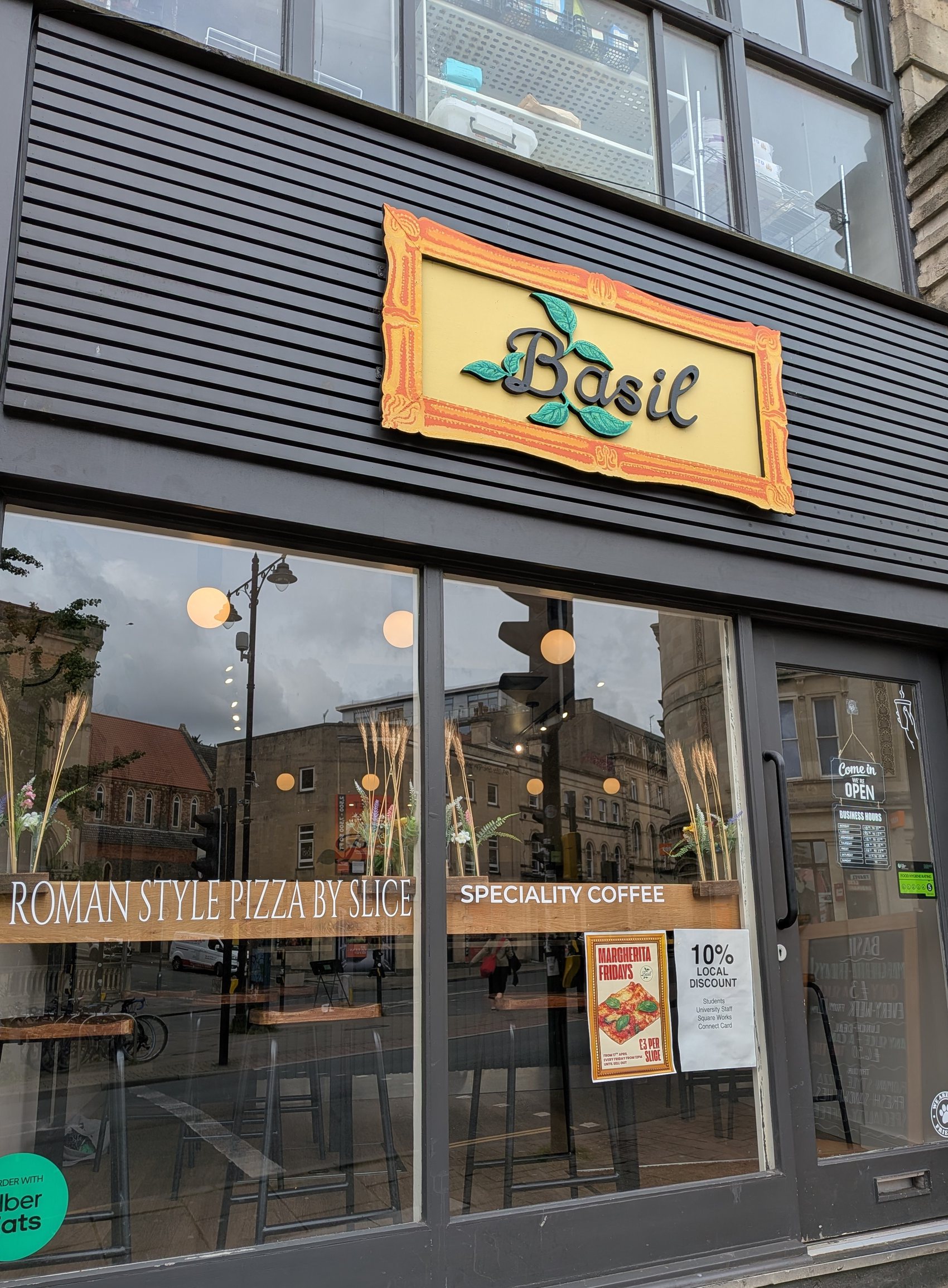 Basil storefront on Queens Road with Roman style pizza and speciality coffee window lettering